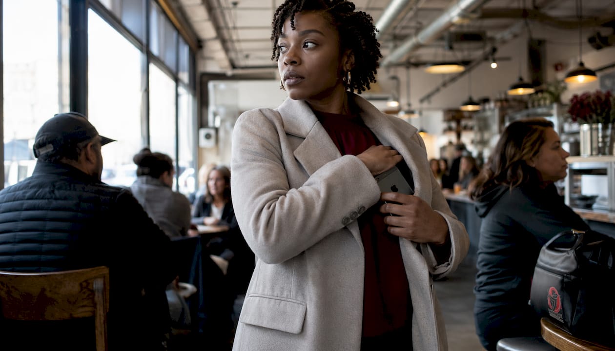Woman securing her phone in a crowded subway environment to prevent pickpocketing