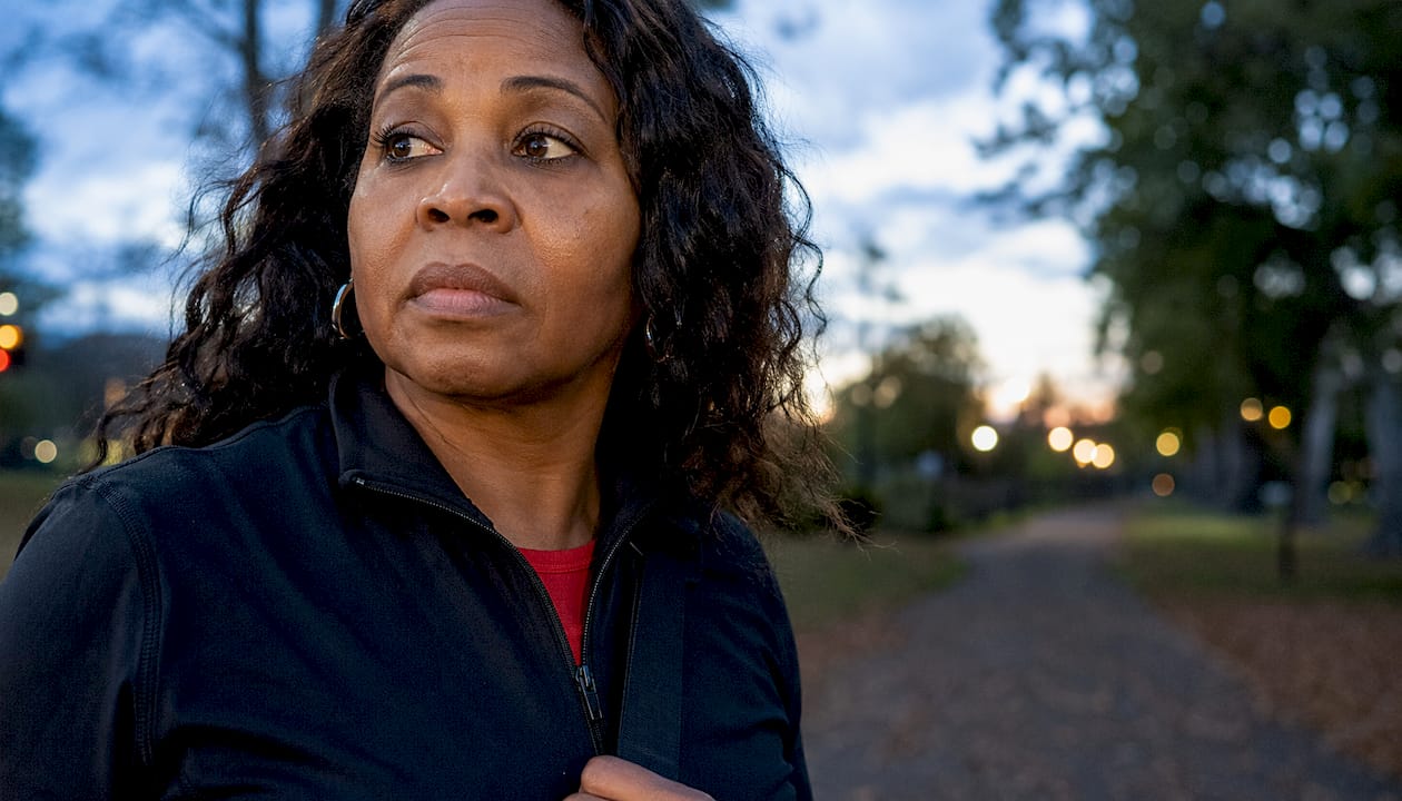 Woman walking outdoors at dusk while practicing situational awareness and staying alert to her surroundings