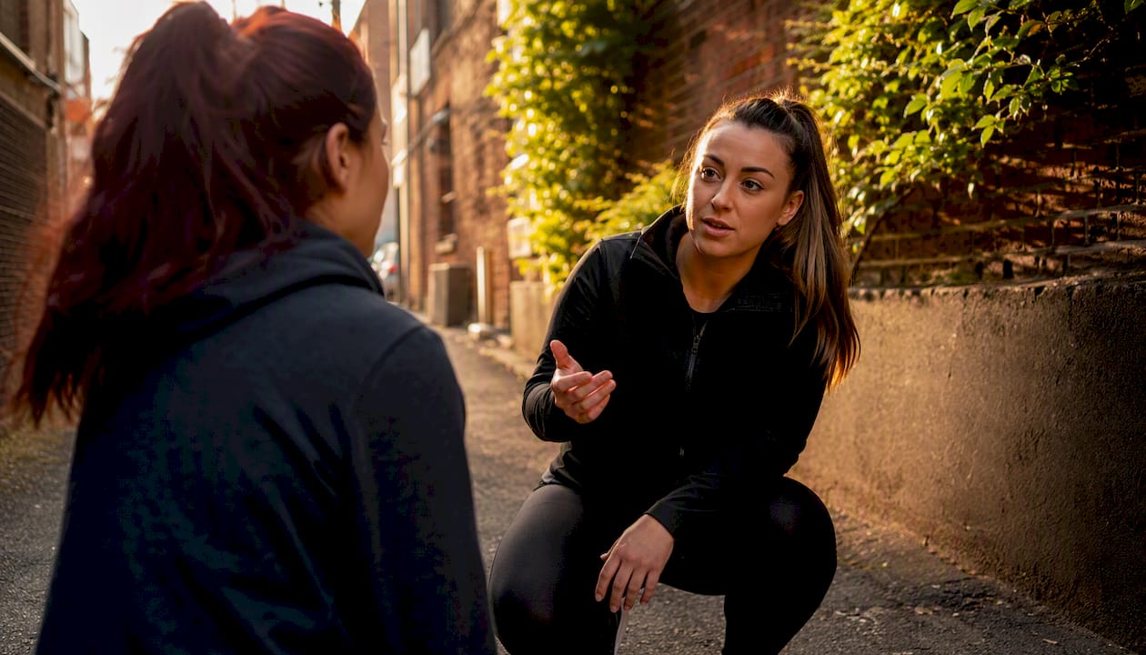 Trainer demonstrating verbal bystander intervention outdoors