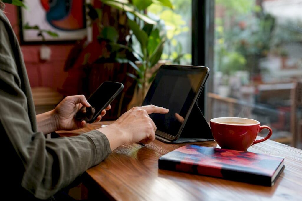 Hands adjusting privacy settings on phone and laptop