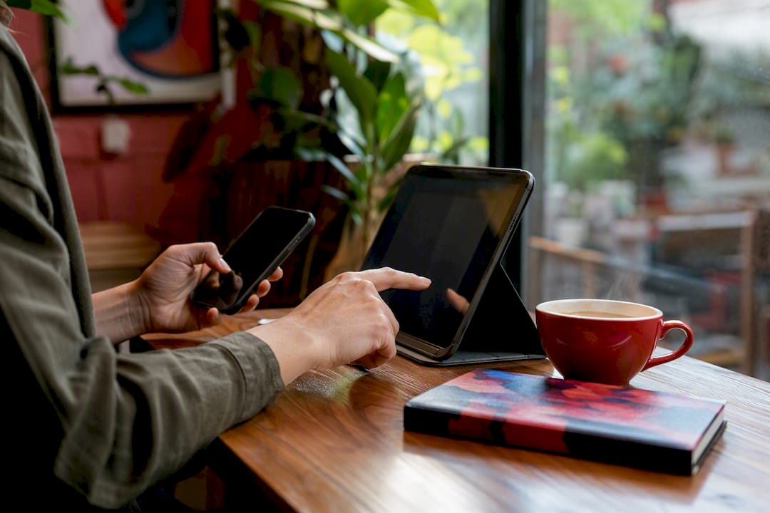 Hands adjusting privacy settings on phone and laptop